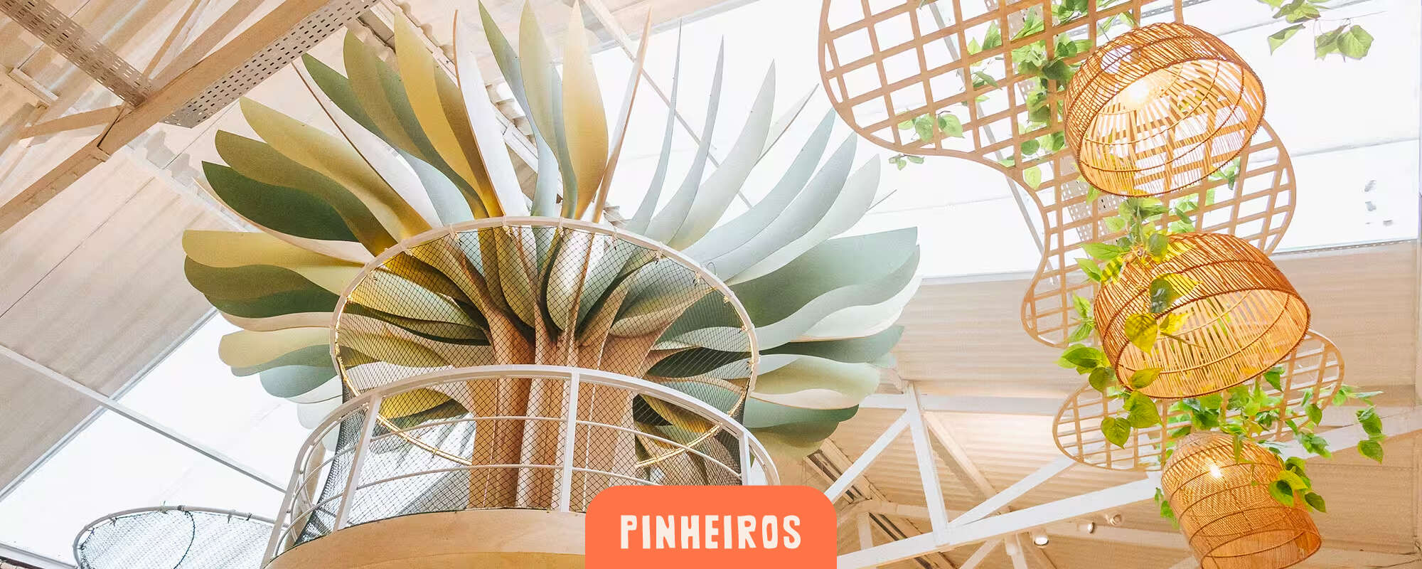 Cachola Pinheiros - estrutura decorativa em formato de planta suspensa com luminárias de rattan e folhagens penduradas